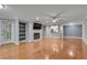 Living room with hardwood floors and large windows, fireplace with shelving and view to dining and kitchen areas at 1015 Dunbar Dr, Dunwoody, GA 30338