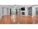 Large living room with hardwood floors, a fireplace, built-in shelving, and a large window with a wooded view at 1015 Dunbar Dr, Dunwoody, GA 30338