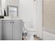 Bathroom features modern grey vanity, white toilet, and tiled shower with white shower curtain at 3 Becker Nw Pl, Atlanta, GA 30307