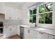 Bright white kitchen with modern appliances and a scenic view from the window at 3 Becker Nw Pl, Atlanta, GA 30307