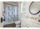 Neutral bathroom featuring a toilet, vanity with sink, mirror, dark floors and shower with a curtain at 3182 Windsor Lake Ne Dr, Atlanta, GA 30319