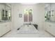Bright bathroom featuring marble floors, double vanities and a soaking tub at 3182 Windsor Lake Ne Dr, Atlanta, GA 30319