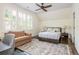 Bright bedroom with a ceiling fan, multiple windows, a bed and a comfortable sitting area with a sofa at 3182 Windsor Lake Ne Dr, Atlanta, GA 30319