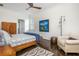 Bright bedroom featuring neutral walls, dark floors, a bed, sitting chair and modern decor with a ceiling fan at 3182 Windsor Lake Ne Dr, Atlanta, GA 30319