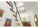 Elegant foyer staircase featuring art and a view of the dark wood front door and entry chandelier at 3182 Windsor Lake Ne Dr, Atlanta, GA 30319