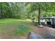 Serene backyard featuring a lush lawn, mature trees, and a cozy swing set for relaxation and enjoyment at 3184 Newcastle Way, Snellville, GA 30039