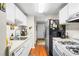 Galley kitchen featuring white cabinets and appliances, with laminate floors and an exterior door at 3184 Newcastle Way, Snellville, GA 30039