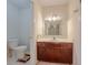 Bathroom featuring a toilet, vanity with sink and mirror, and neutral decor at 5334 Post Road Pass, Stone Mountain, GA 30088