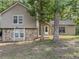 Charming two-story home with stone accents and a cozy front entrance, surrounded by mature trees at 5334 Post Road Pass, Stone Mountain, GA 30088