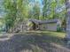 Home exterior features a wooded lot, neutral colors, and multiple windows allowing for ample natural light at 5334 Post Road Pass, Stone Mountain, GA 30088