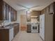 Traditional kitchen features a white refrigerator and range oven, dark cabinets, and tile floors at 5334 Post Road Pass, Stone Mountain, GA 30088