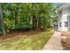 A large backyard area with lush green grass and sidewalk at 605 Buttercup Trce, Johns Creek, GA 30022