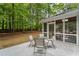 A cozy backyard featuring a patio area with outdoor seating and a screen porch at 605 Buttercup Trce, Johns Creek, GA 30022