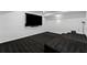 Basement with wall mounted TV, black carpet and stairs to a raised platform at 605 Buttercup Trce, Johns Creek, GA 30022