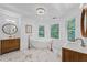 Bright bathroom featuring a chandelier, free standing tub, marble floors and wood vanities at 605 Buttercup Trce, Johns Creek, GA 30022