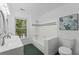 Well-lit bathroom features a double sink, tub, and leafy artwork at 605 Buttercup Trce, Johns Creek, GA 30022