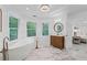 Bright bathroom featuring a soaking tub, wood vanity, and elegant marble floors at 605 Buttercup Trce, Johns Creek, GA 30022