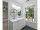 Well-lit bathroom with dual sinks, beadboard mirrors, and a large window at 605 Buttercup Trce, Johns Creek, GA 30022