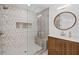 Walk-in shower with glass door, tiled walls, and wooden vanity with round mirror at 605 Buttercup Trce, Johns Creek, GA 30022