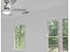 Bright bedroom with large windows offering lush tree views and a modern ceiling fan at 605 Buttercup Trce, Johns Creek, GA 30022