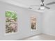 Bright bedroom with large windows offering tree views and a modern ceiling fan at 605 Buttercup Trce, Johns Creek, GA 30022