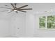 Clean, all-white bedroom featuring a ceiling fan and natural light at 605 Buttercup Trce, Johns Creek, GA 30022