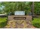 A stone community sign with colorful flower beds and mature landscaping at 605 Buttercup Trce, Johns Creek, GA 30022