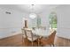 Dining room with hardwood floors, a modern chandelier, and bright natural light at 605 Buttercup Trce, Johns Creek, GA 30022