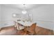 Dining room with hardwood floors, a modern chandelier, and bright natural light at 605 Buttercup Trce, Johns Creek, GA 30022