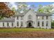 Stately two-story home boasts a symmetrical facade, arched windows, and meticulously manicured landscaping at 605 Buttercup Trce, Johns Creek, GA 30022