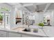 Gourmet kitchen featuring granite counters, modern sink, and views into an adjacent living area at 605 Buttercup Trce, Johns Creek, GA 30022