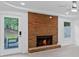 Bright living room showcasing a brick fireplace, ceiling fan and exterior access at 605 Buttercup Trce, Johns Creek, GA 30022