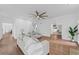 Open living room boasts hardwood floors, ceiling fan and view to office space at 605 Buttercup Trce, Johns Creek, GA 30022
