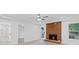 Bright living room features a brick fireplace, modern ceiling fan, and updated flooring at 605 Buttercup Trce, Johns Creek, GA 30022