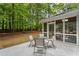 Cozy screened-in porch with dining area, ideal for enjoying the outdoors with a serene backyard view at 605 Buttercup Trce, Johns Creek, GA 30022