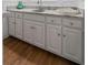 Close up of the wet bar featuring white cabinets and marble countertop at 605 Buttercup Trce, Johns Creek, GA 30022