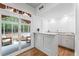 Charming wet bar with marble countertop, white cabinets, and access to screened porch at 605 Buttercup Trce, Johns Creek, GA 30022