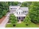 Beautiful aerial view of a pristine white farmhouse with a detached three car garage at 201 Dobbs Rd, Woodstock, GA 30188
