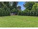 Large backyard with a green lawn, framed by trees and a soccer goal, offering ample space for recreation at 201 Dobbs Rd, Woodstock, GA 30188