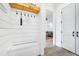 A welcoming entryway with a bench, a coat rack, shiplap walls, and hardwood floors at 201 Dobbs Rd, Woodstock, GA 30188