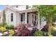 Charming front porch with white columns, ceiling fans, and lush landscaping enhancing the home's curb appeal at 201 Dobbs Rd, Woodstock, GA 30188