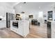 Open kitchen flows into the dining area, featuring an island with built-in microwave and stainless steel refrigerator at 201 Dobbs Rd, Woodstock, GA 30188