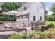 Inviting outdoor patio with comfortable seating, a dining area, string lights, and lush landscaping at 201 Dobbs Rd, Woodstock, GA 30188