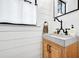 Chic powder room with a unique vanity, modern faucet, shiplap walls, and stylish decor at 201 Dobbs Rd, Woodstock, GA 30188