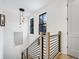 A well lit staircase featuring black iron railings, white walls, and a modern pendant light at 201 Dobbs Rd, Woodstock, GA 30188