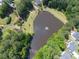 Aerial view of a community pond with fountain surrounded by lush greenery and walking trails at 5034 Kingsbridge Pass, Powder Springs, GA 30127