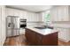 Kitchen boasts an island, stainless appliances, white cabinetry, and stone countertops at 5034 Kingsbridge Pass, Powder Springs, GA 30127