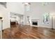 Spacious living room with hardwood floors, a fireplace, high ceilings, and a view of the open kitchen at 5034 Kingsbridge Pass, Powder Springs, GA 30127