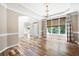 Sunlit room featuring hardwood floors, a tray ceiling, and a large window overlooking lush greenery at 5034 Kingsbridge Pass, Powder Springs, GA 30127