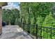 A spacious back porch shows intricate railing details with the trees in the distance at 8340 Royal Melbourne Way, Duluth, GA 30097